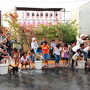 子供達が打ち水している写真