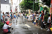 大勢の人が打ち水をしている写真