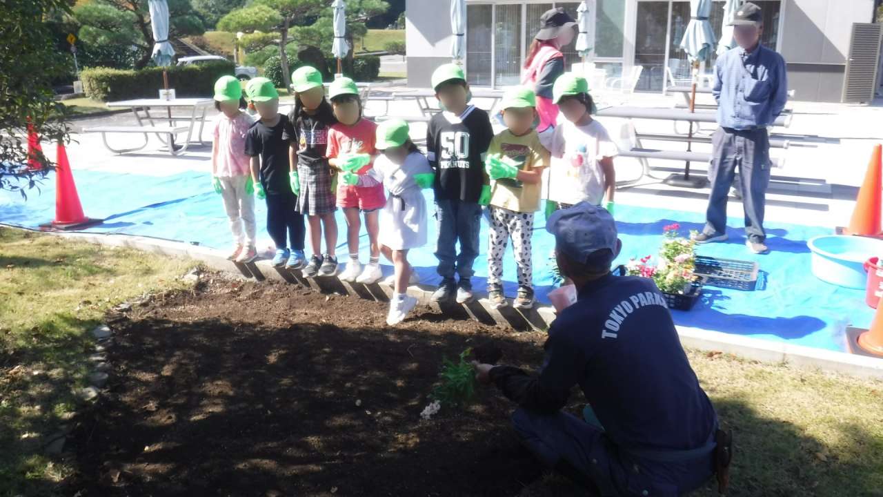 いこいの広場、園児と職員、花苗モザ入り