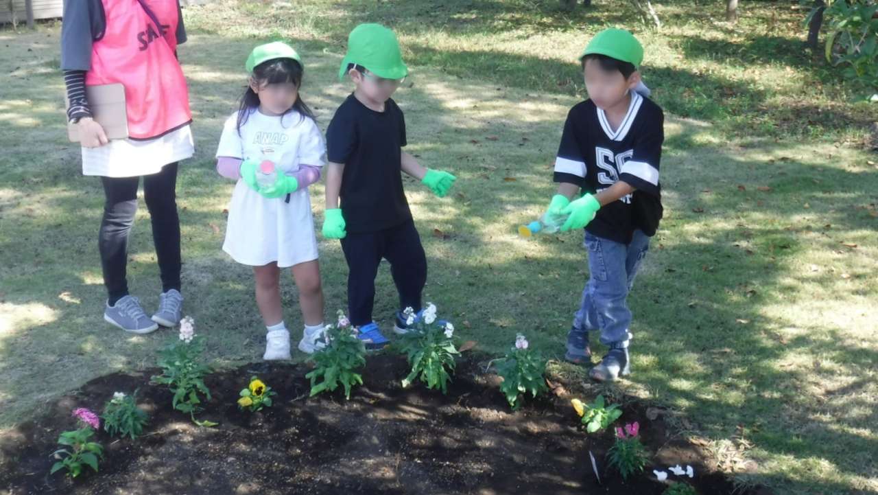 いこいの広場、園児の水やり、花苗モザ入り②